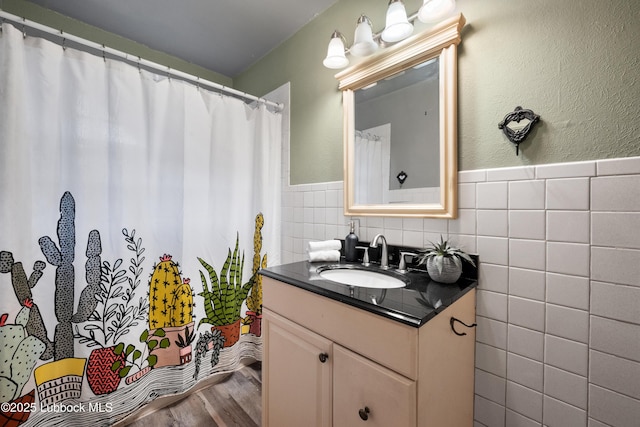 2005 32nd St, Lubbock, TX 79411 - full bath with vanity, tile walls, wood finished floors, a wainscoted wall, and curtained shower