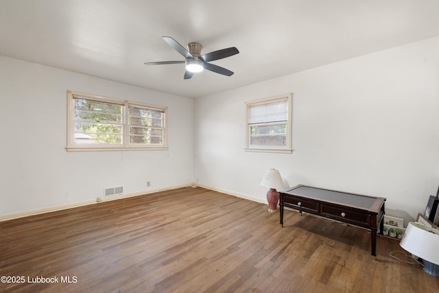 2005 32nd St, Lubbock, TX 79411 - unfurnished room with wood finished floors, healthy amount of natural light, a ceiling fan, and baseboards