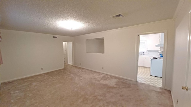 carpeted empty room with ornamental molding and a textured ceiling