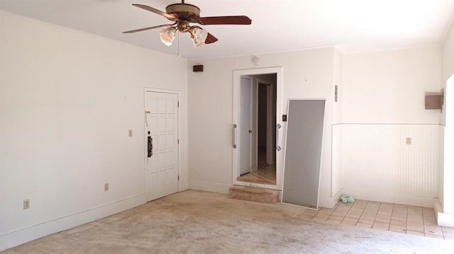 spare room with crown molding, light colored carpet, and ceiling fan