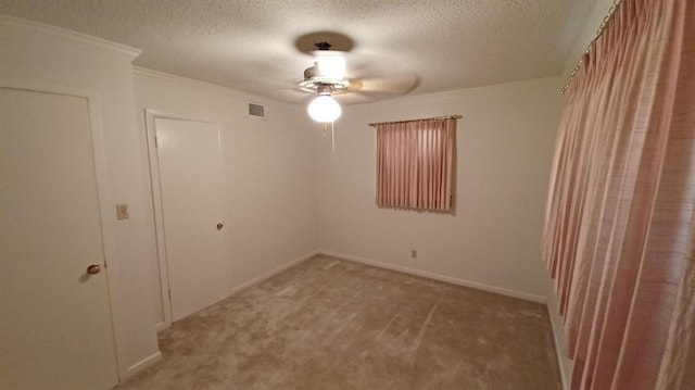 interior space featuring crown molding, light colored carpet, and a textured ceiling