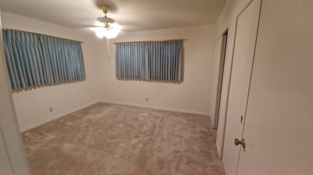 unfurnished bedroom featuring light colored carpet, ceiling fan, and a closet