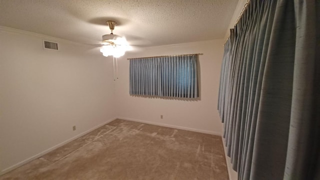 empty room featuring ceiling fan, carpet floors, and a textured ceiling