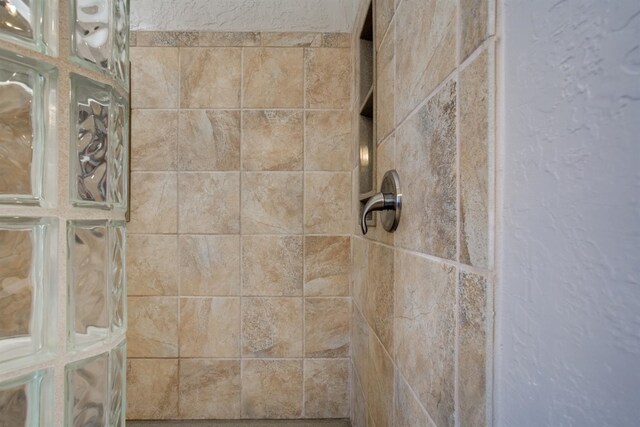 interior details with a tile shower