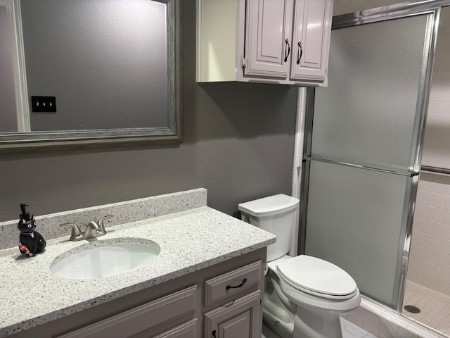 bathroom with vanity, toilet, and a shower with shower door