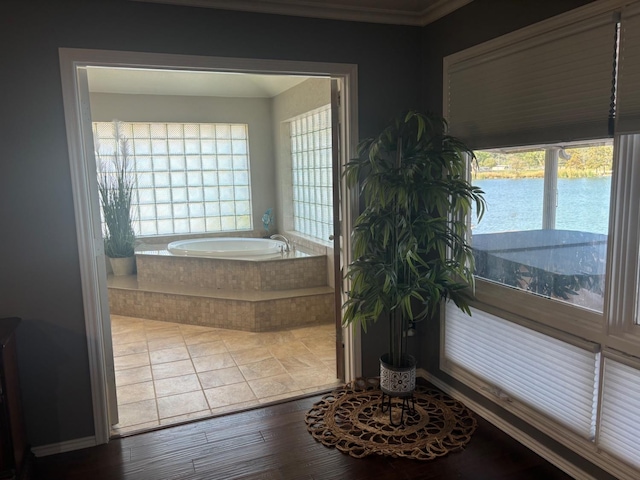 bathroom featuring tiled tub and a water view