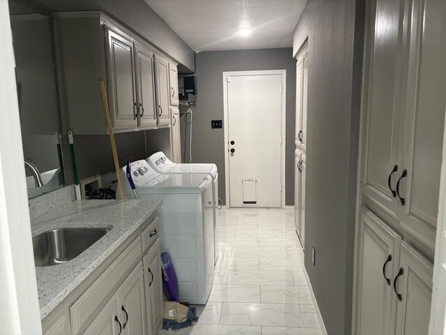 laundry room with separate washer and dryer, sink, and cabinets