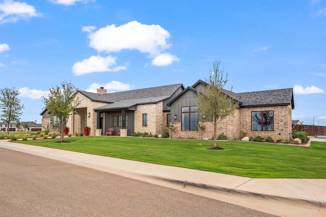 7733 46th St, Lubbock, TX 79407 - view of front of property featuring brick siding, a front yard, a chimney, and roof with shingles