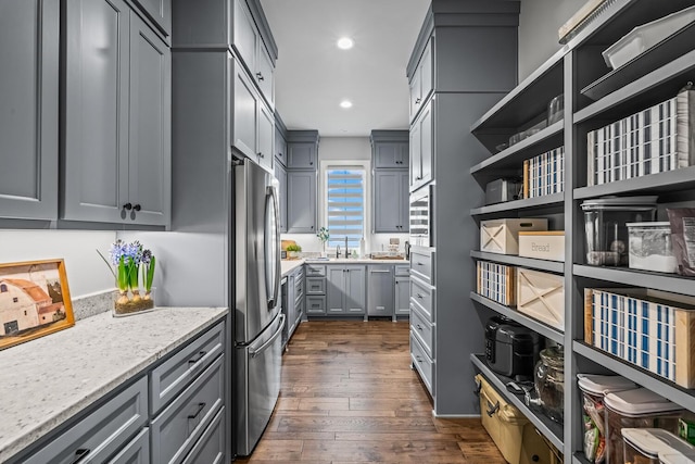 7733 46th St, Lubbock, TX 79407 - kitchen with freestanding refrigerator, gray cabinetry, dark wood finished floors, recessed lighting, and light stone counters
