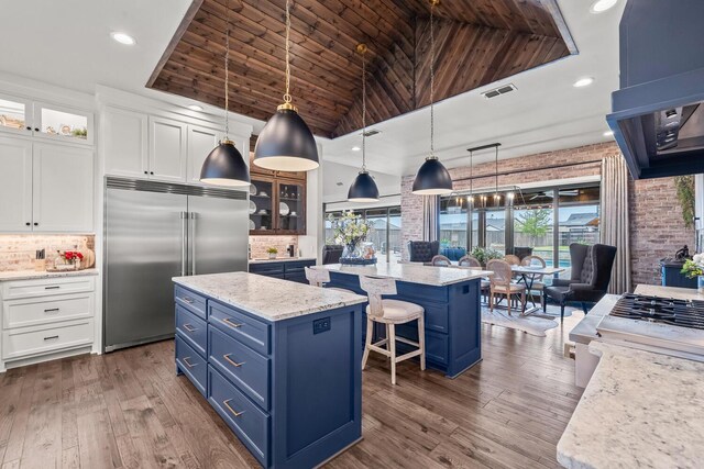 7733 46th St, Lubbock, TX 79407 - kitchen with blue cabinets, built in refrigerator, a center island, healthy amount of natural light, and wooden ceiling