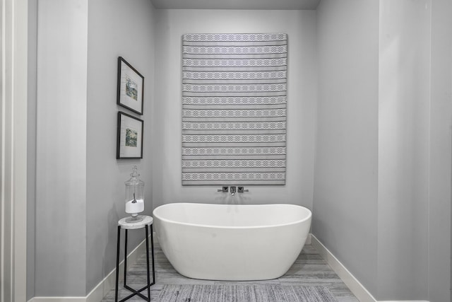 7733 46th St, Lubbock, TX 79407 - bathroom featuring a freestanding bath and wood finished floors