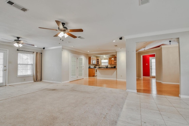 unfurnished living room with ornamental molding, light tile patterned floors, and ceiling fan