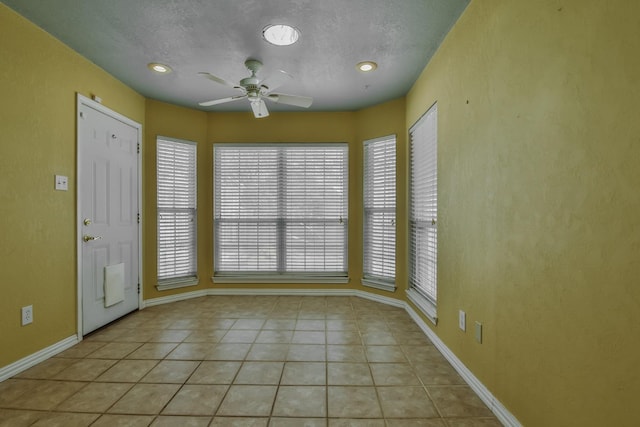 tiled entrance foyer featuring a textured ceiling and ceiling fan