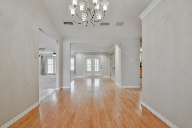 entryway with ornamental molding, a chandelier, and light wood-type flooring