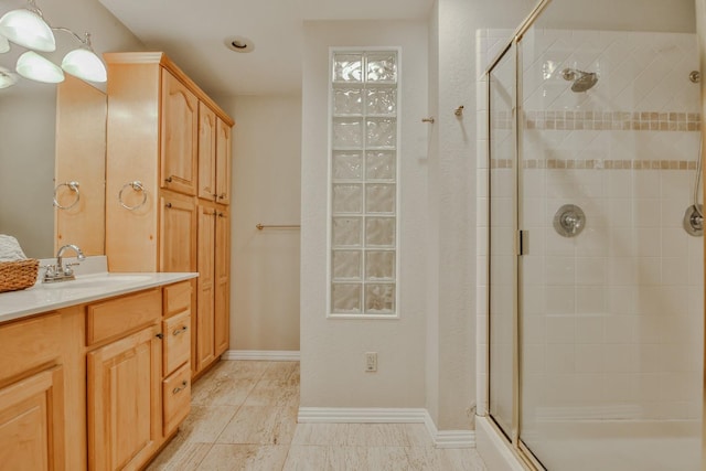 bathroom with vanity and a shower with door