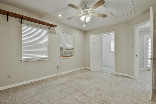 empty room featuring a wealth of natural light, light carpet, ceiling fan, and cooling unit