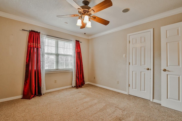 spare room with ornamental molding, light colored carpet, a textured ceiling, and ceiling fan