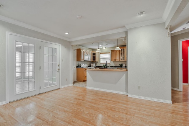 kitchen featuring pendant lighting, crown molding, kitchen peninsula, and light wood-type flooring