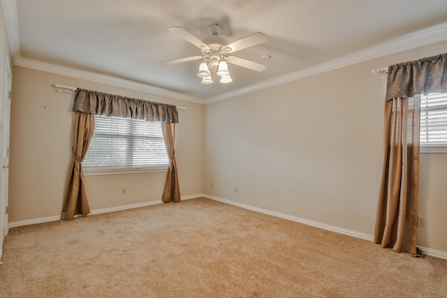 spare room with ceiling fan, light colored carpet, a healthy amount of sunlight, and ornamental molding