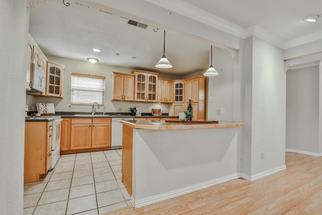 kitchen featuring ornamental molding, light brown cabinetry, white appliances, and decorative light fixtures