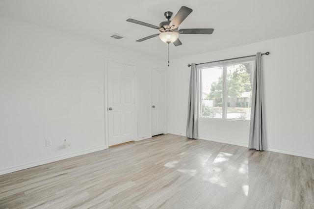 empty room with ceiling fan and light wood-type flooring