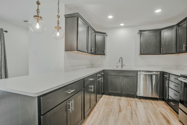 kitchen with sink, hanging light fixtures, light hardwood / wood-style flooring, kitchen peninsula, and stainless steel appliances