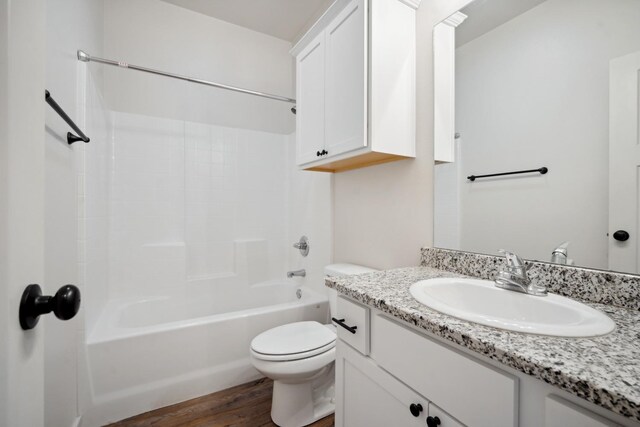 full bathroom with vanity, toilet, shower / bath combination, and wood-type flooring