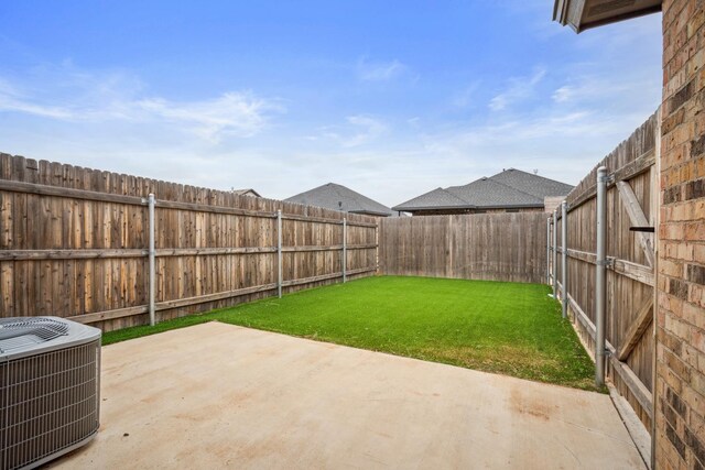 view of yard with central AC unit and a patio area