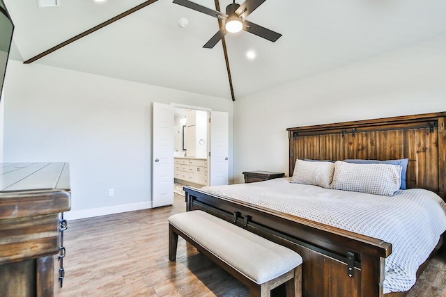 bedroom with lofted ceiling, a ceiling fan, connected bathroom, wood finished floors, and baseboards