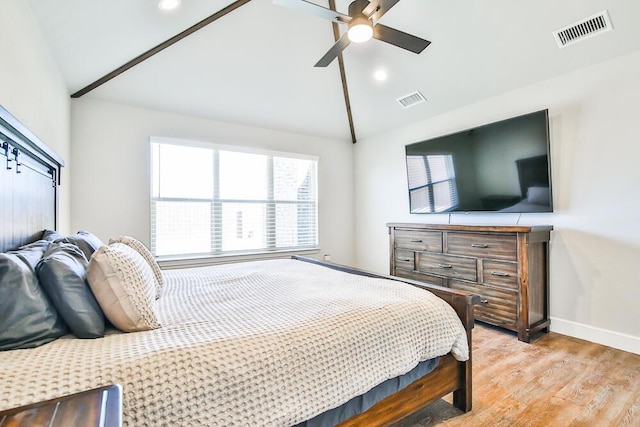 bedroom with visible vents, vaulted ceiling, and wood finished floors