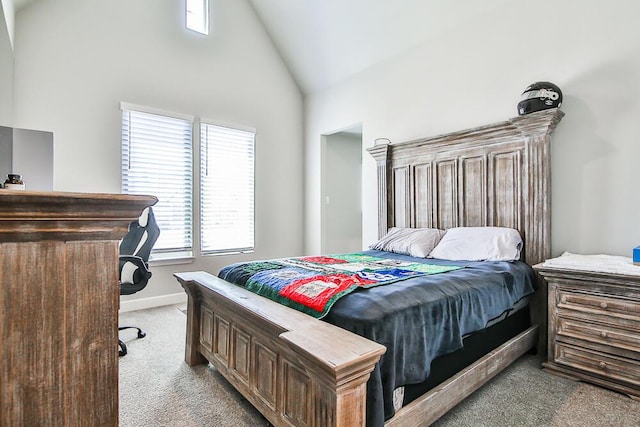 carpeted bedroom featuring high vaulted ceiling and baseboards