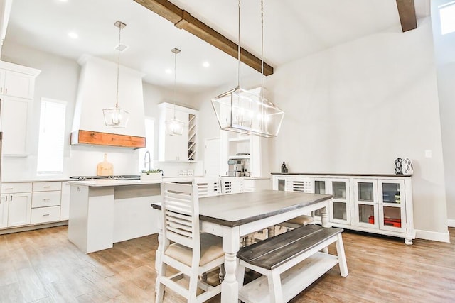 dining room featuring baseboards, beamed ceiling, light wood-style flooring, and recessed lighting