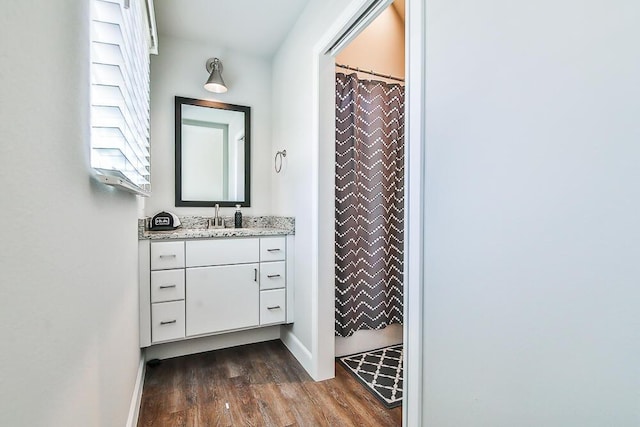 full bathroom with a shower with curtain, wood finished floors, vanity, and baseboards