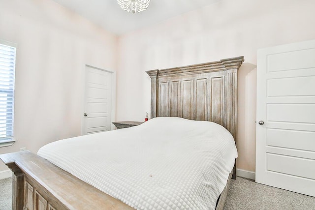 bedroom with baseboards, multiple windows, and light colored carpet