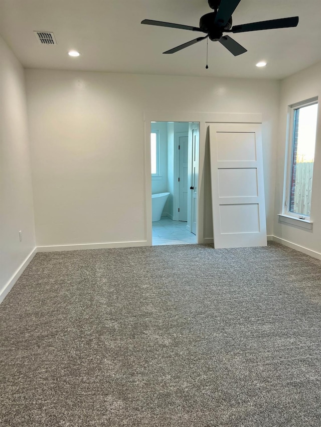 carpeted spare room featuring ceiling fan