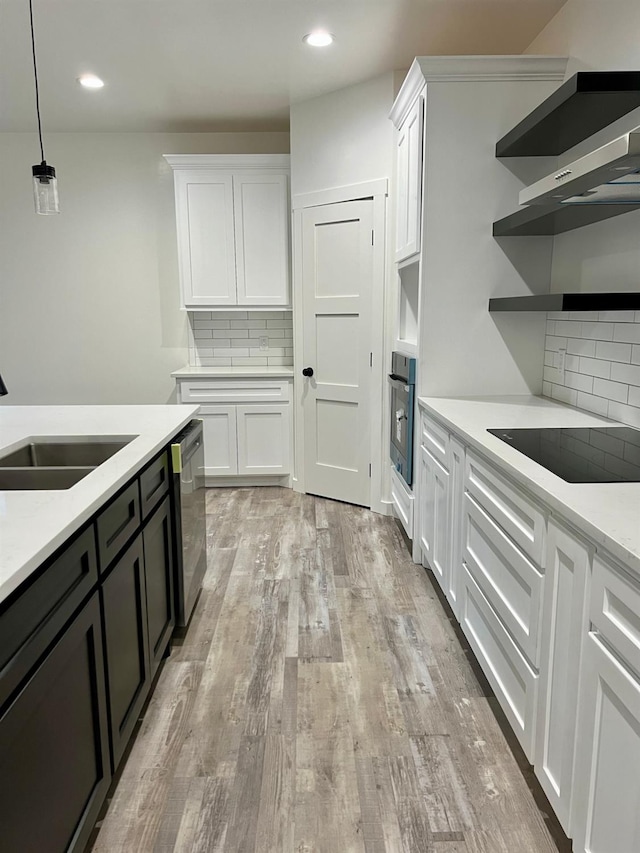 kitchen with decorative light fixtures, sink, oven, white cabinets, and stainless steel dishwasher