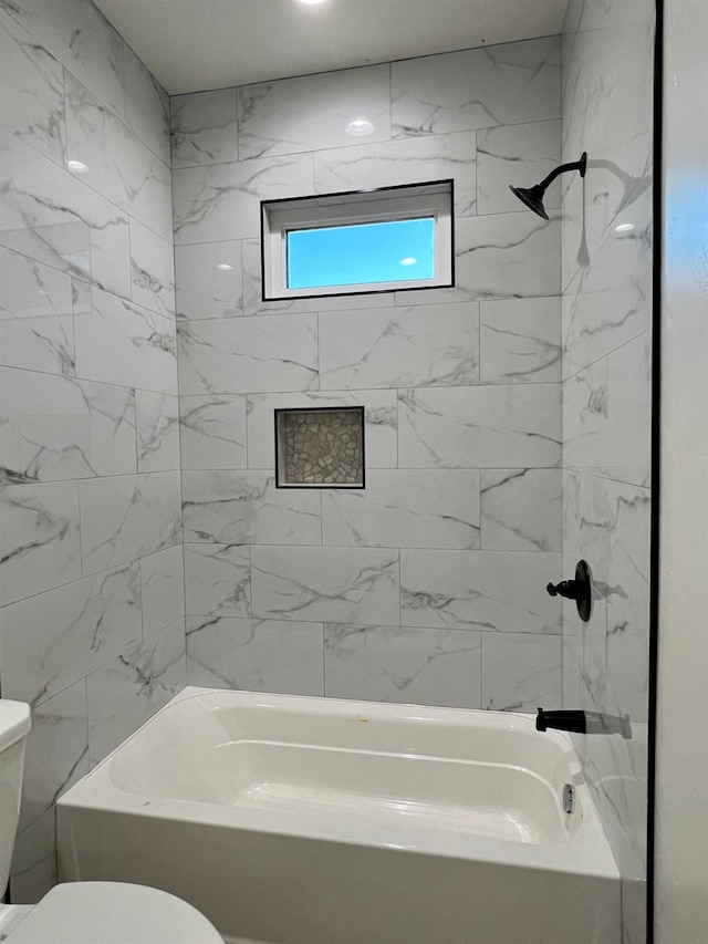 bathroom with toilet and tiled shower / bath combo