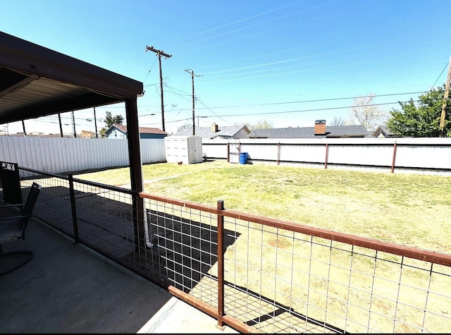 view of yard with an outdoor structure, a shed, and a fenced backyard