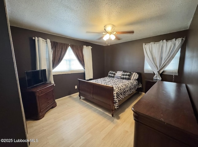 5442 14th St, Lubbock, TX 79416 - bedroom with light wood-style floors, a textured ceiling, ceiling fan, and baseboards