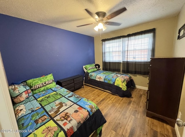 5442 14th St, Lubbock, TX 79416 - bedroom with wood finished floors, a textured ceiling, ceiling fan, and baseboards