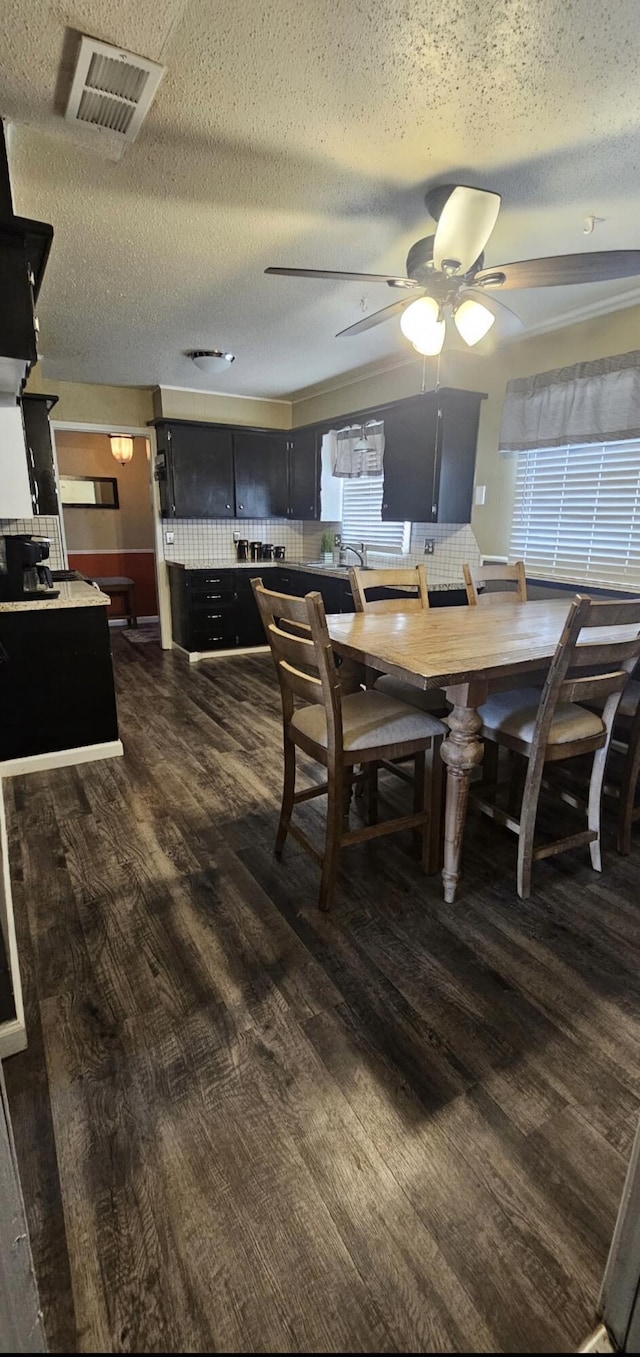 dining space with a textured ceiling, visible vents, and ceiling fan