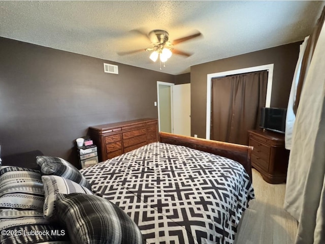 5442 14th St, Lubbock, TX 79416 - bedroom with wood finished floors, a ceiling fan, and a textured ceiling
