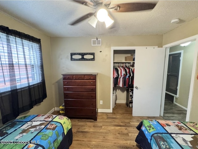 5442 14th St, Lubbock, TX 79416 - bedroom with wood finished floors, a closet, a textured ceiling, and baseboards