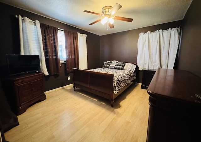 bedroom with baseboards, a ceiling fan, light wood-style floors, and a textured ceiling