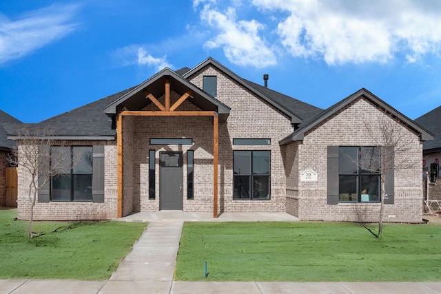 view of front of house with brick siding and a front yard