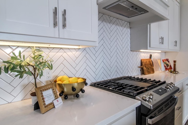 kitchen with custom exhaust hood, decorative backsplash, white cabinets, and gas stove