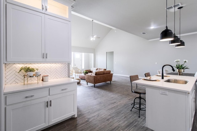 kitchen with visible vents, a breakfast bar, a sink, light countertops, and hanging light fixtures