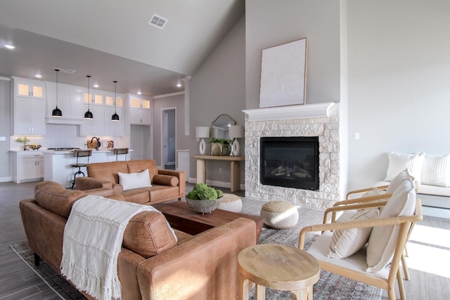 living room with high vaulted ceiling, dark wood-type flooring, and a fireplace