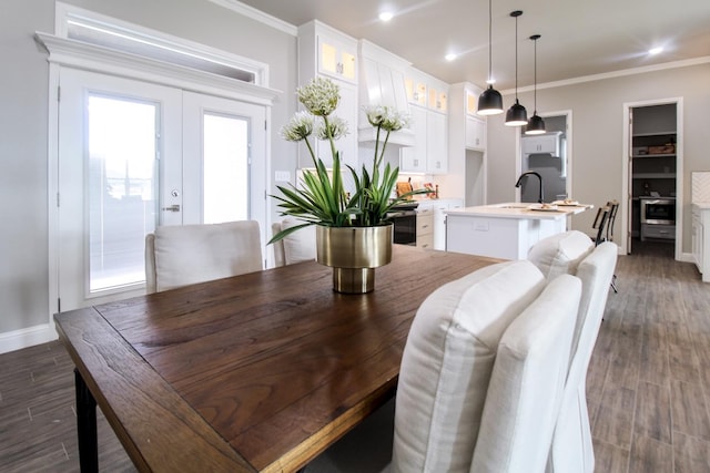 dining room featuring sink, crown molding, dark wood-type flooring, and french doors