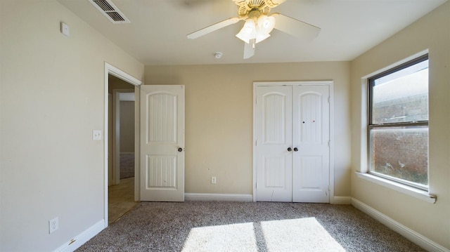 unfurnished bedroom with multiple windows, light colored carpet, a closet, and ceiling fan